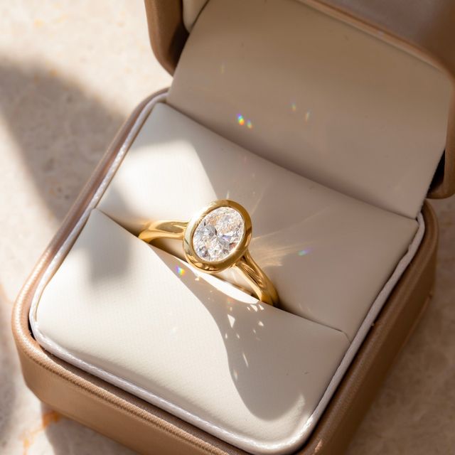 1.50 Carat Lab Grown Oval Bezel Engagement Ring In Yellow Gold – London